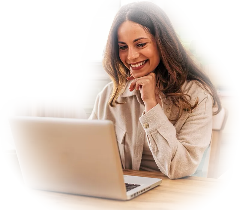 A smiling woman taking an online course on her laptop