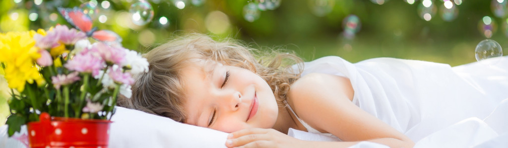 Kid sleeping in spring garden